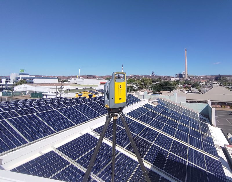 Trimble X7 laser scanner on a tripod on a roof covered with solar panels